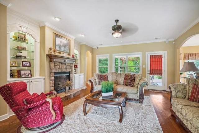 living room featuring a fireplace, ornamental molding, dark hardwood / wood-style floors, and ceiling fan