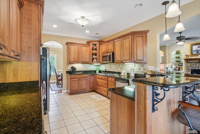 kitchen with pendant lighting, a kitchen bar, light tile patterned floors, kitchen peninsula, and stainless steel appliances