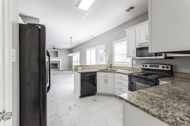 kitchen with sink, pendant lighting, white cabinets, and black appliances