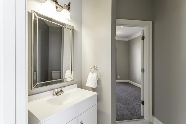 bathroom featuring ornamental molding, vanity, and toilet