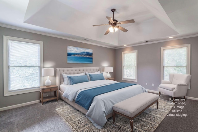 bedroom featuring crown molding, a raised ceiling, ceiling fan, and dark colored carpet