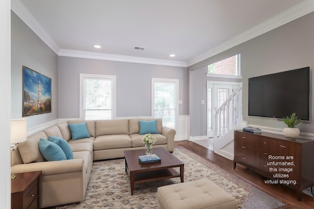 living room with ornamental molding, light hardwood / wood-style floors, and a healthy amount of sunlight