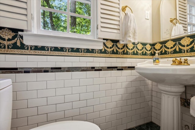 bathroom featuring wainscoting and tile walls