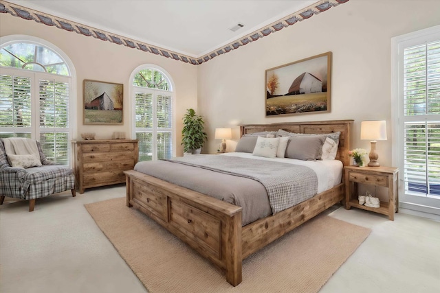 bedroom with light carpet, multiple windows, and visible vents