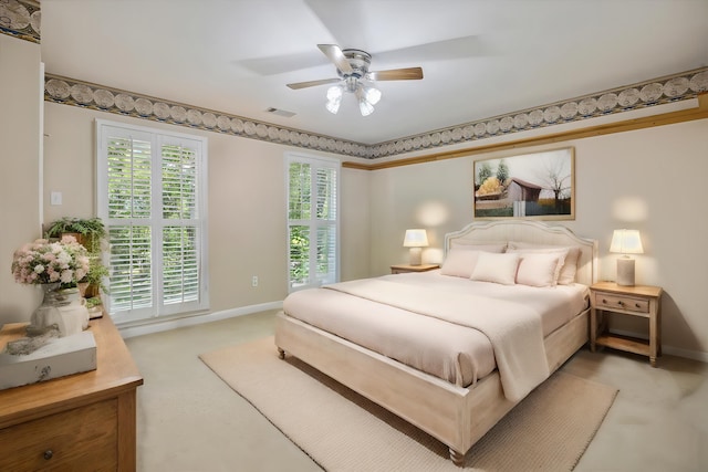 bedroom with light carpet, visible vents, a ceiling fan, and baseboards