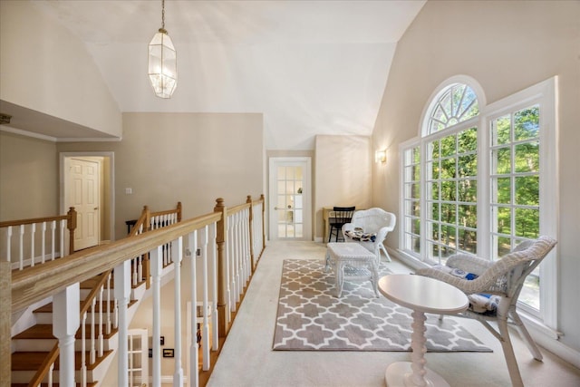 corridor with high vaulted ceiling and light colored carpet