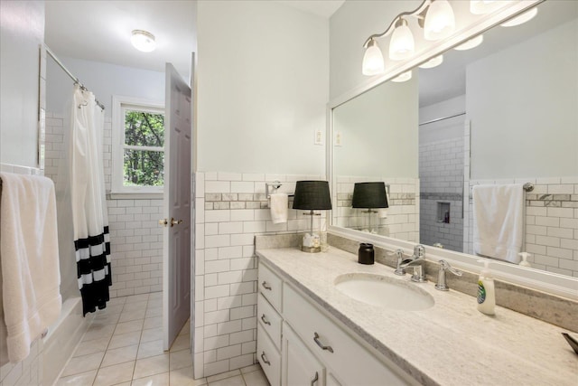 bathroom with tile patterned flooring, wainscoting, tile walls, and vanity