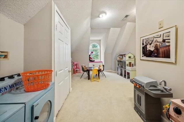 recreation room featuring lofted ceiling, visible vents, light colored carpet, and a textured ceiling