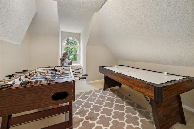 game room with light carpet, vaulted ceiling, a textured ceiling, and baseboards