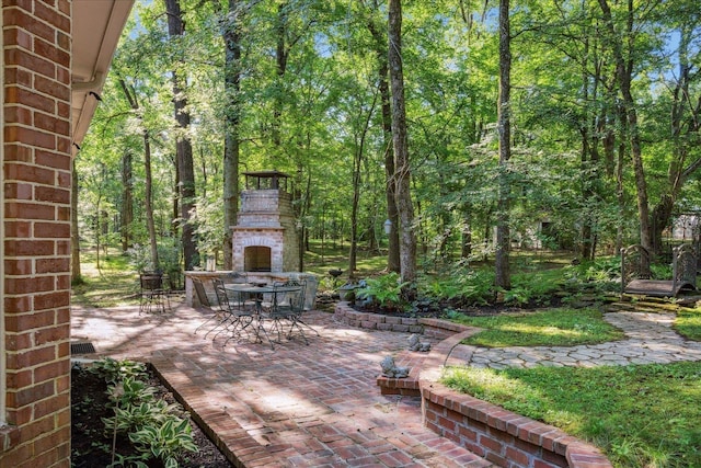 view of patio / terrace with outdoor dining space and an outdoor fireplace