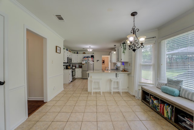 kitchen featuring light tile patterned flooring, a kitchen bar, stainless steel appliances, and kitchen peninsula