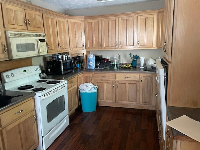 kitchen featuring dark wood-type flooring and white appliances