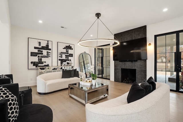 living room with a fireplace and light wood-type flooring