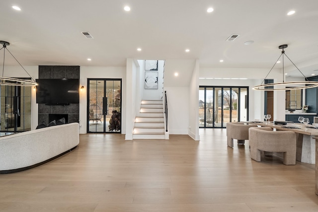 living room with light hardwood / wood-style flooring, a fireplace, and french doors