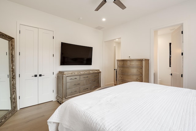 bedroom with ceiling fan, light hardwood / wood-style floors, and a closet