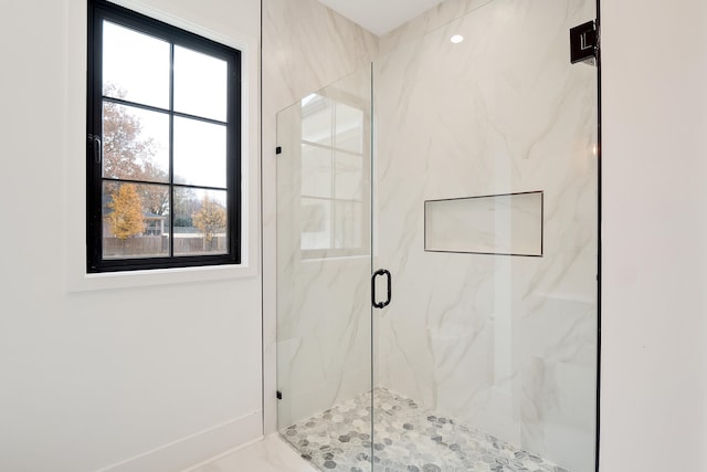 bathroom with a shower with shower door and a wealth of natural light