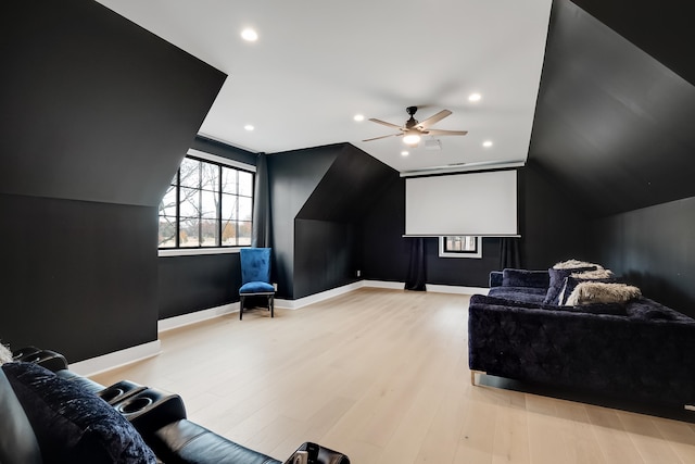 home theater featuring light hardwood / wood-style floors, ceiling fan, and vaulted ceiling