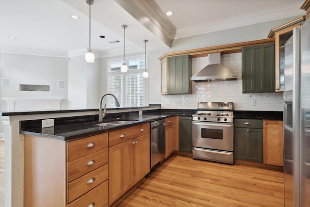 kitchen with appliances with stainless steel finishes, decorative light fixtures, dark stone countertops, kitchen peninsula, and wall chimney range hood