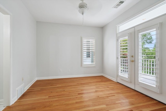 unfurnished room featuring french doors and light wood-type flooring