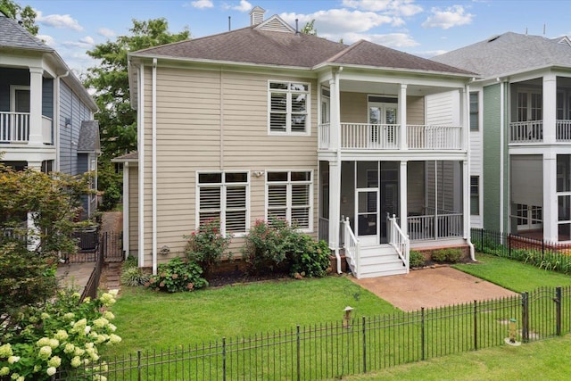 back of property with a yard, a sunroom, a balcony, and central air condition unit