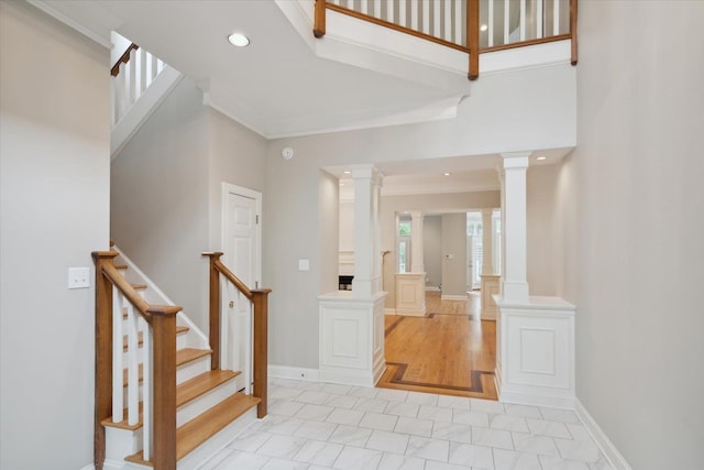 entrance foyer featuring ornamental molding, a high ceiling, and ornate columns