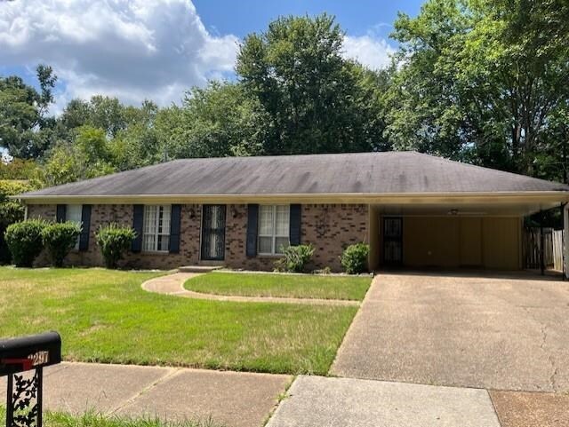 ranch-style house with a carport and a front yard