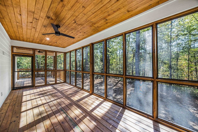 unfurnished sunroom with ceiling fan, a healthy amount of sunlight, and wooden ceiling