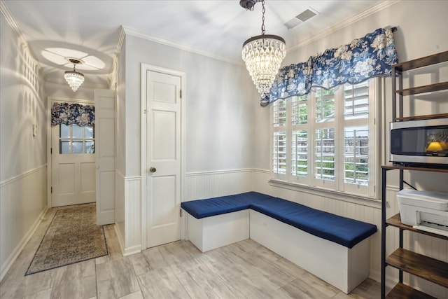 interior space with an inviting chandelier, crown molding, and light hardwood / wood-style flooring