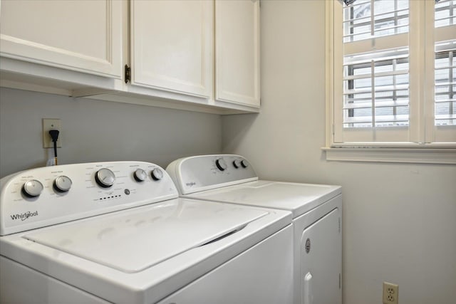 clothes washing area with washing machine and clothes dryer and cabinets