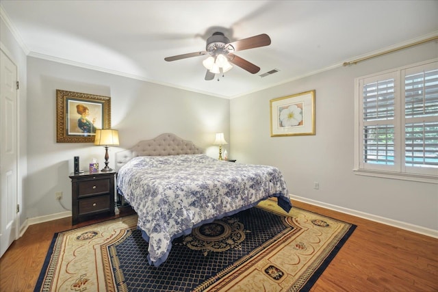 bedroom with hardwood / wood-style flooring, crown molding, and ceiling fan