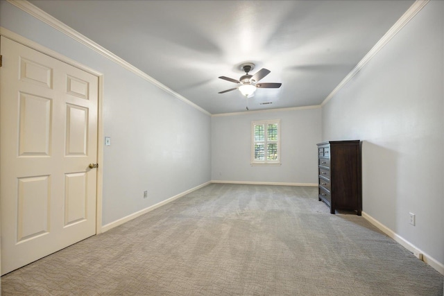 carpeted spare room featuring ceiling fan and ornamental molding