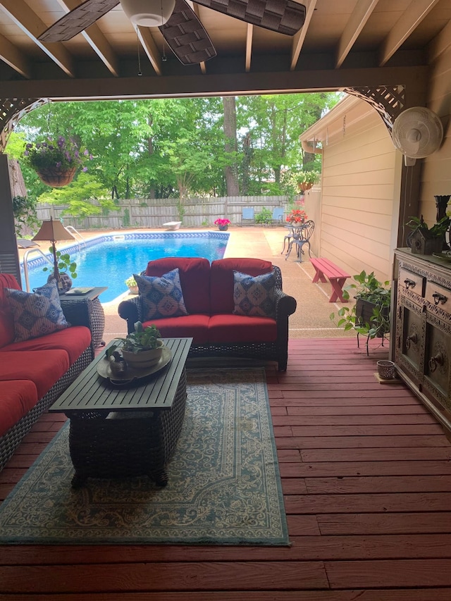 wooden deck with an outdoor living space and a fenced in pool