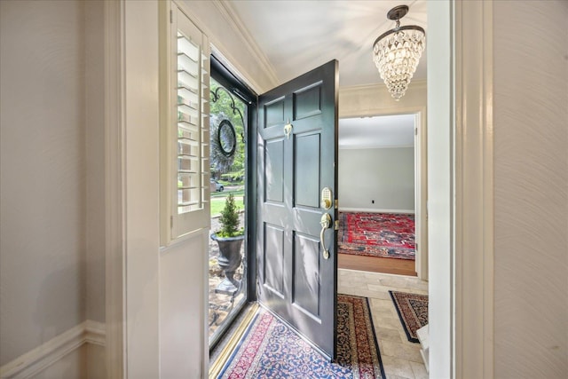 tiled entryway featuring a notable chandelier and crown molding