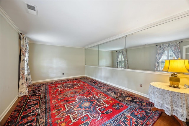 interior space with wood-type flooring and crown molding