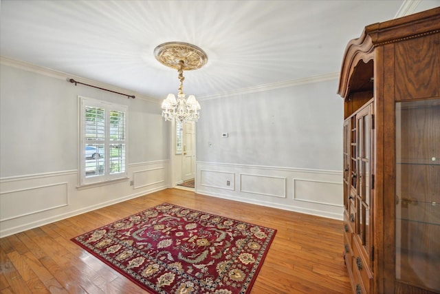 dining room with an inviting chandelier, crown molding, and light hardwood / wood-style floors