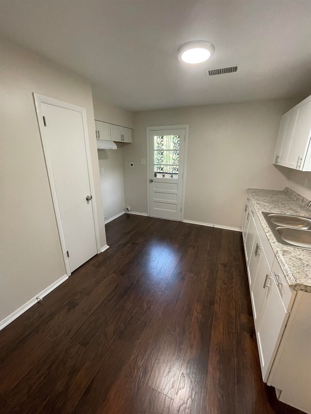 kitchen with sink, dark hardwood / wood-style flooring, and white cabinets