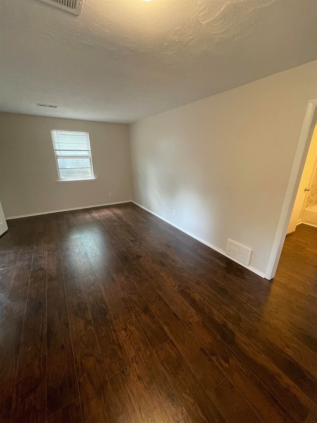 unfurnished room with dark hardwood / wood-style flooring