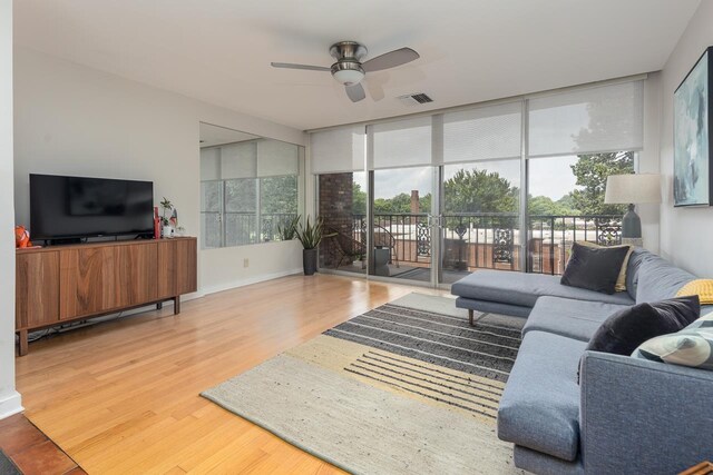 living room featuring a wealth of natural light, hardwood / wood-style flooring, and ceiling fan