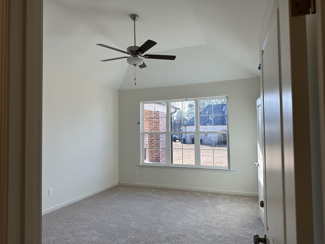 carpeted empty room featuring vaulted ceiling and ceiling fan