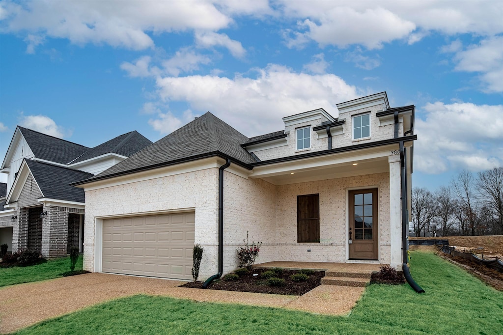 view of front facade featuring a garage, a front yard, and covered porch