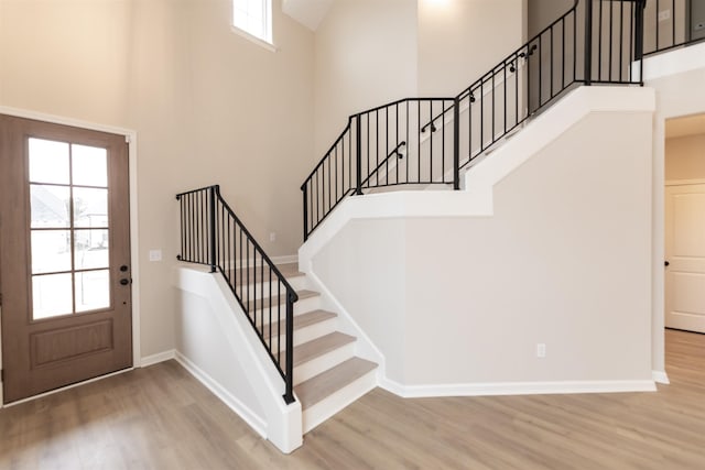 entryway with a high ceiling, a healthy amount of sunlight, and light hardwood / wood-style floors