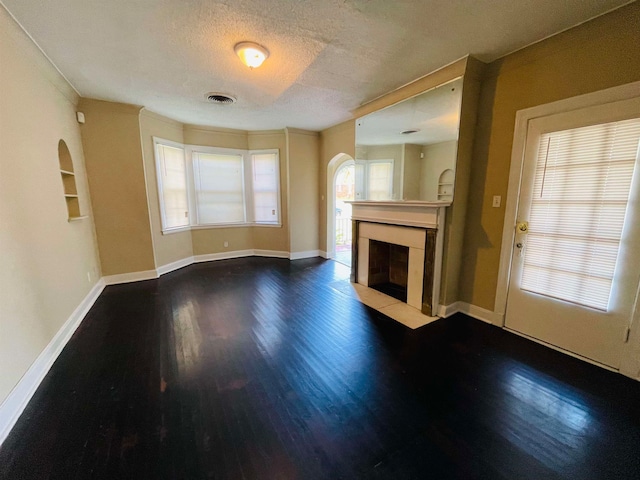 unfurnished living room with hardwood / wood-style floors, a fireplace, and a textured ceiling