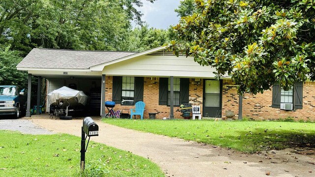 ranch-style home featuring a front yard, a porch, and a carport