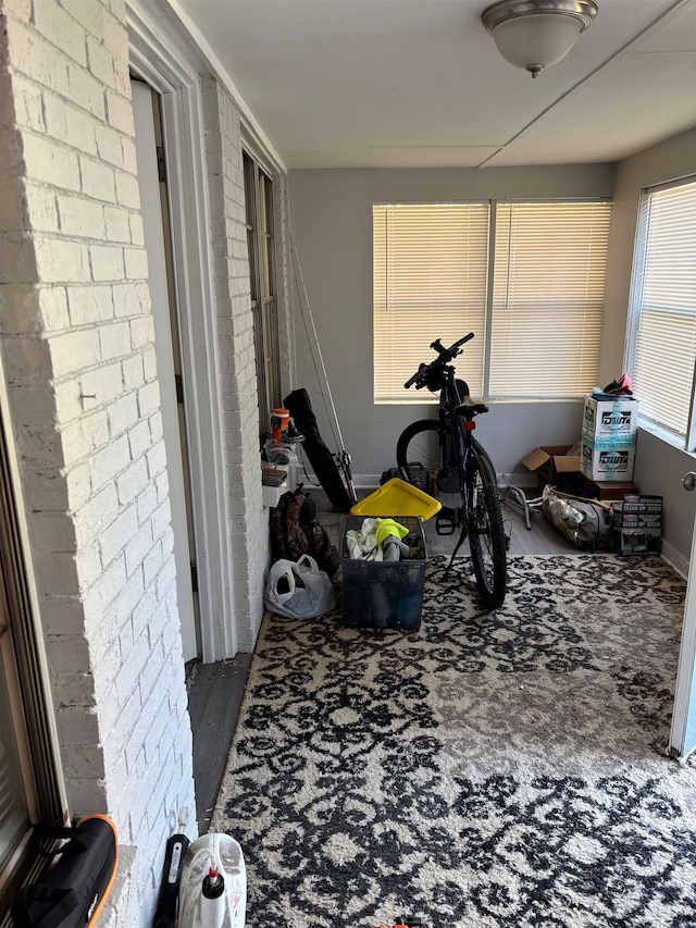 interior space with wood-type flooring and brick wall