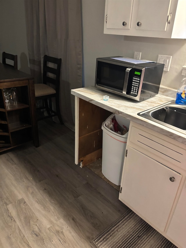 kitchen with sink, light hardwood / wood-style flooring, and white cabinets