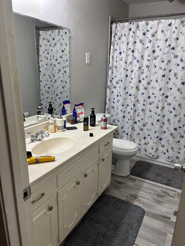 bathroom with hardwood / wood-style flooring, vanity, toilet, and a shower with shower curtain