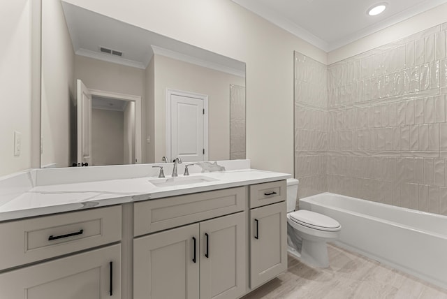 full bathroom featuring vanity, tiled shower / bath, ornamental molding, and toilet