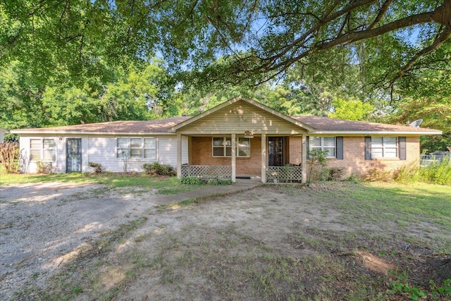 single story home with a front lawn and covered porch