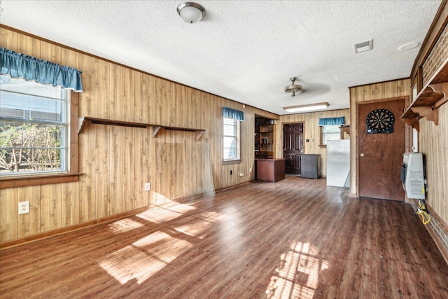 unfurnished living room with heating unit, dark hardwood / wood-style floors, and a textured ceiling