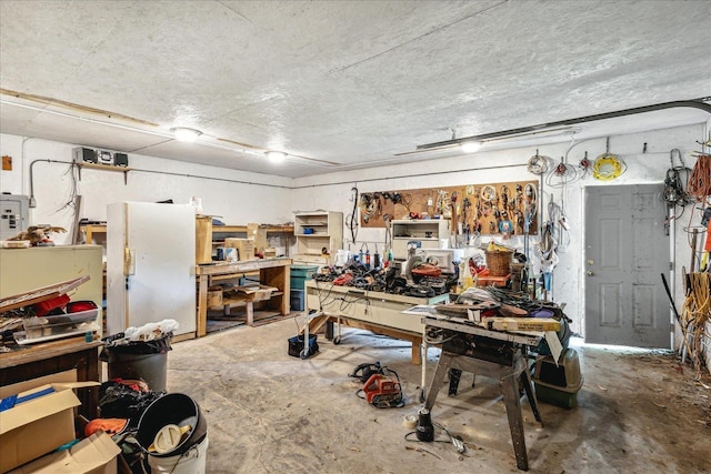 interior space with a workshop area and white fridge